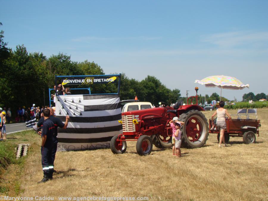 Plan rapproché. Sur une remorque agricole : <i>Bienvenue en Bretagne</i>. Le <i>Gwenn ha Du</i> a une bande blanche de plus écrite <i>Bro Naoned</i>... Plan rapproché. Sur une remorque agricole : <i>Bienvenue en Bretagne</i>. Le <i>Gwenn ha Du</i> a une bande blanche de plus écrite <i>Bro Naoned</i>...