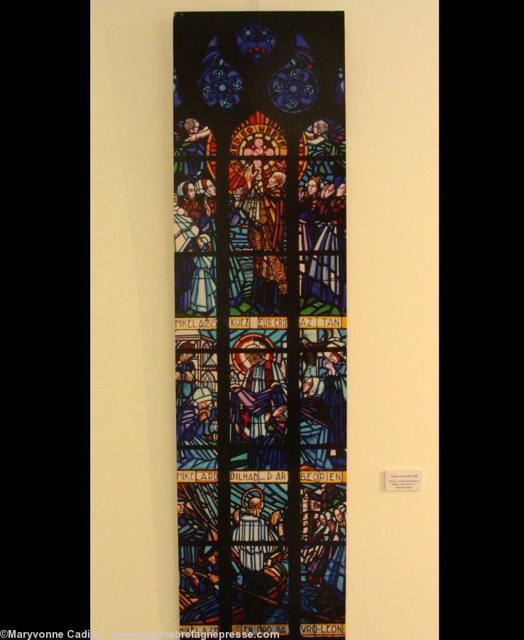 Église du Conquet. Vitrail de La vie de Dom Mikel Le Nobletz. 1932. On lit : <i>Mikel a ziskuez eur croaz tan. Mikel a ro dilhad d’ar beorien. Mikel a zeu endro da vro Leon</i>. Michel montre une croix de feu. Donne des vêtements aux pauvres. Revient en L Église du Conquet. Vitrail de La vie de Dom Mikel Le Nobletz. 1932. On lit : <i>Mikel a ziskuez eur croaz tan. Mikel a ro dilhad d’ar beorien. Mikel a zeu endro da vro Leon</i>. Michel montre une croix de feu. Donne des vêtements aux pauvres. Revient en L
