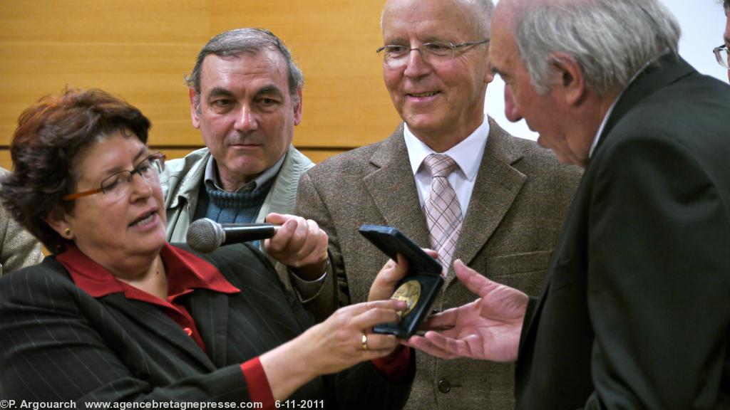 Madame la maire de Pouldreuzic Marie-Thérèse Gourlaouen
remet la médaille de la ville à Michel Priziac président le
l\'association des écrivains bretons (à droite). Au centre Bernard
Le Floc\'h vice président de l\'institut culturel de Bretagne.
