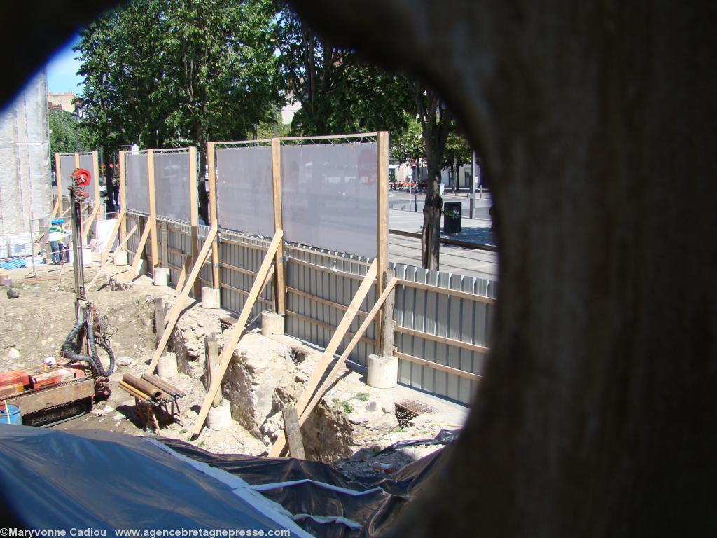 Nantes. Visites guidées du site archéologique tour du Haut-Pas et porte Sauvetout. Deux trous sont pratiqués dans la palissade le long de l\'escalier (voir photo 1). On aperçoit des restes de murailles sous le trottoir du Cours. Photo du 3 mai plan rapproché. Nantes. Visites guidées du site archéologique tour du Haut-Pas et porte Sauvetout. Deux trous sont pratiqués dans la palissade le long de l\'escalier (voir photo 1). On aperçoit des restes de murailles sous le trottoir du Cours. Photo du 3 mai plan rapproché.