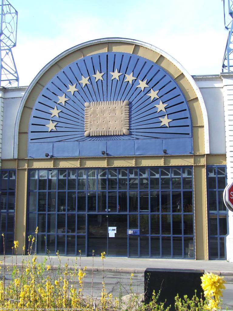 Le Petit Beurre LU à Nantes. Façade réalisée par Christophe Drouet symbole de la marque LU. Une partie de l\'aile ouest de l\'usine LU conservée. Maintenant lieu du QG de l\'opération <i>Voyage à Nantes</i>. <b>Cliquer pour voir la photo en entier</b>. Le Petit Beurre LU à Nantes. Façade réalisée par Christophe Drouet symbole de la marque LU. Une partie de l\'aile ouest de l\'usine LU conservée. Maintenant lieu du QG de l\'opération <i>Voyage à Nantes</i>. <b>Cliquer pour voir la photo en entier</b>.