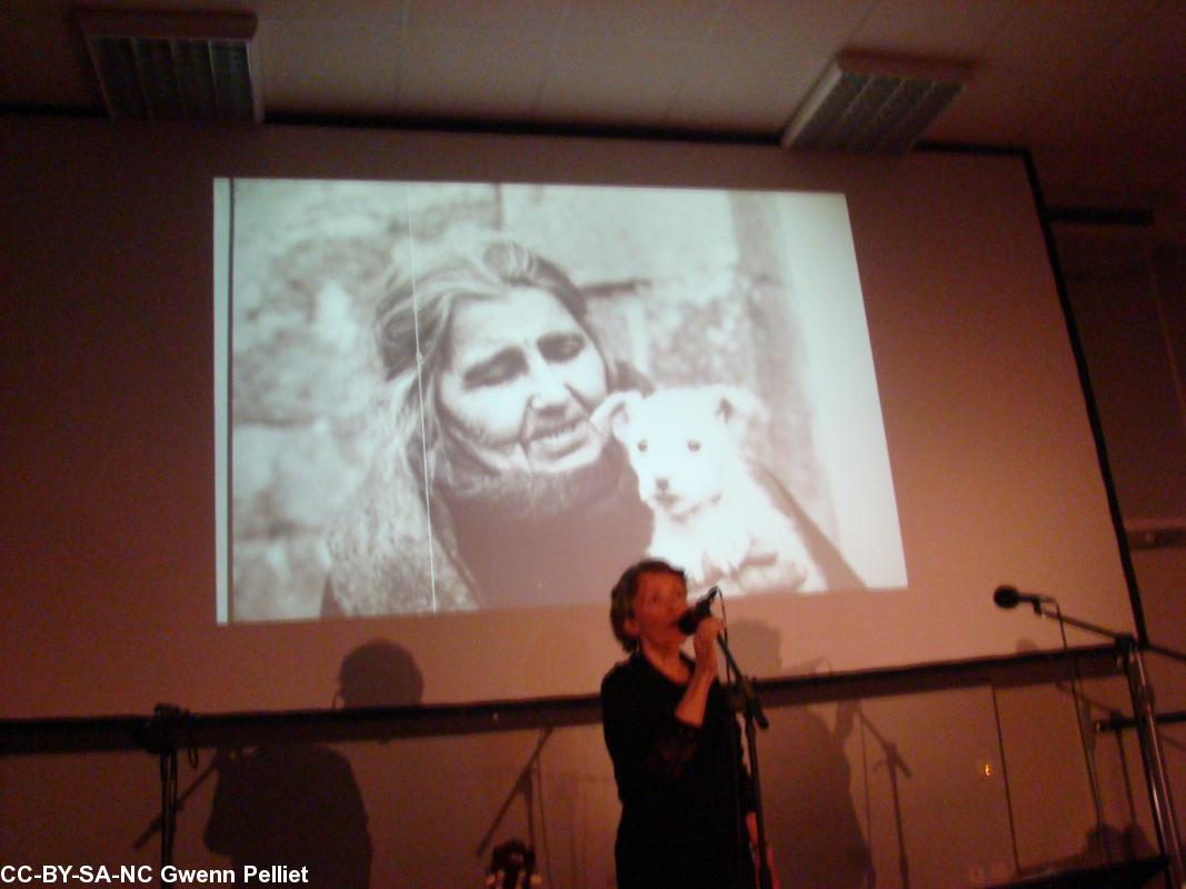 Mona Ar Beg lisant un poème d\'Anjela Duval avec
la photo d\'A.D. en arrière-plan