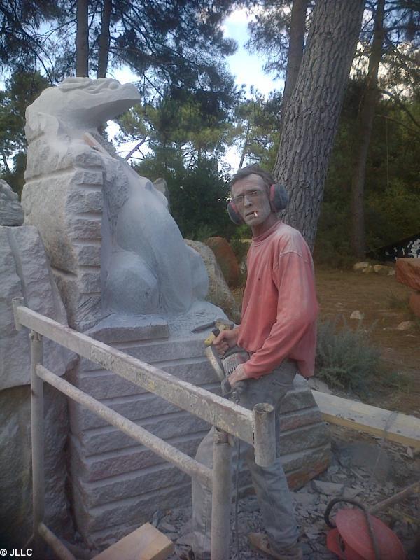 Gwenn Guillemot sculpte un dragon de pierre sur le terrain de Koad Sav pell.