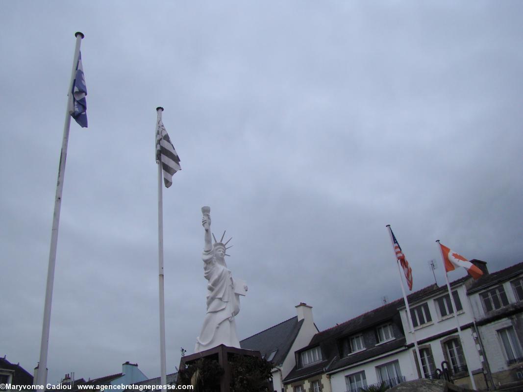 Gourin. La réplique de la statue de la Liberté de New York de Bartholdi rappelle l'émigration massive des Bretons du Kreizh Breizh aux Amériques. Entourée des drapeaux du Québec à droite et de Québec ville à gauche. Le manque de vent masquait ses fleurs de lys blanches sur fond bleu et la croix blanche. Gourin. La réplique de la statue de la Liberté de New York de Bartholdi rappelle l'émigration massive des Bretons du Kreizh Breizh aux Amériques. Entourée des drapeaux du Québec à droite et de Québec ville à gauche. Le manque de vent masquait ses fleurs de lys blanches sur fond bleu et la croix blanche.