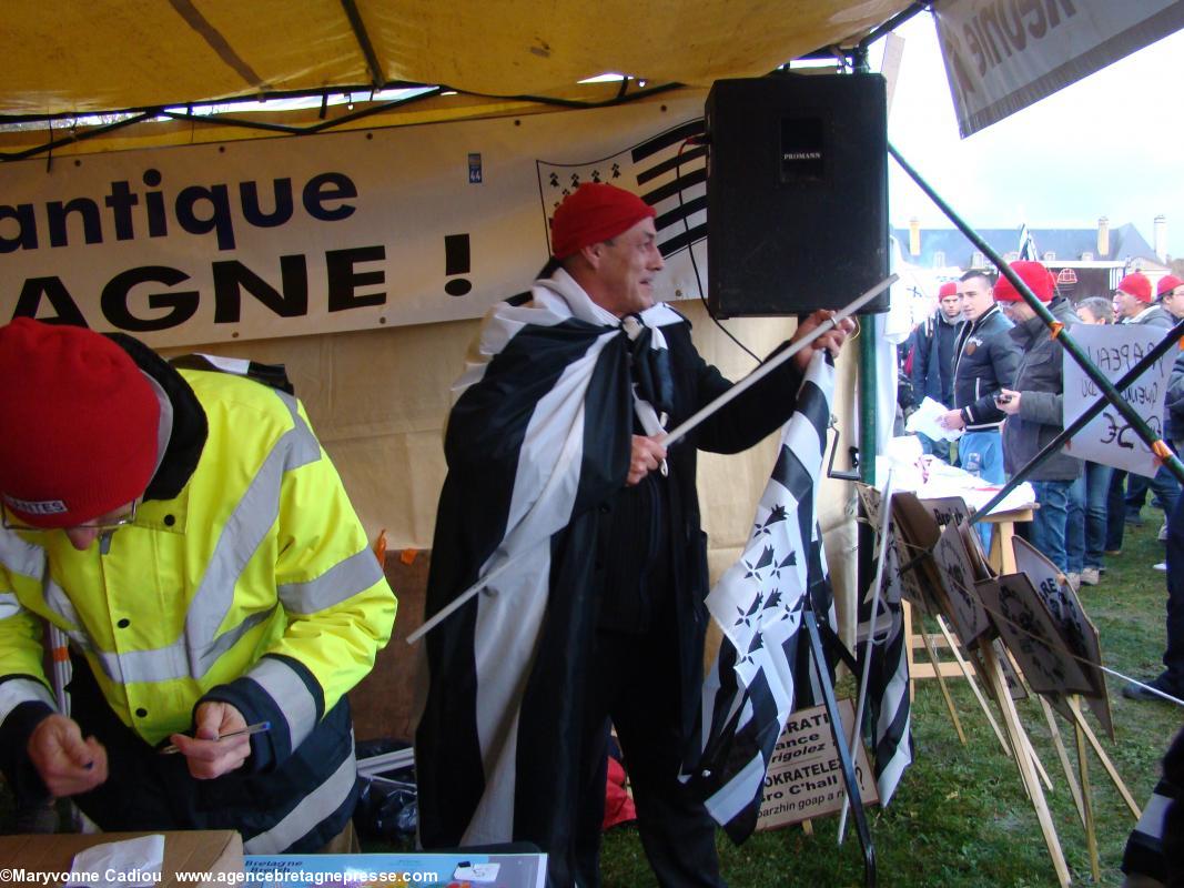 Henry Colliot, venu de Nantes, et organisateur du transport par car,  très en forme, propose les drapeaux bretons pour le défilé. Bonnets Rouges, Karaez 30 nov. 2013.