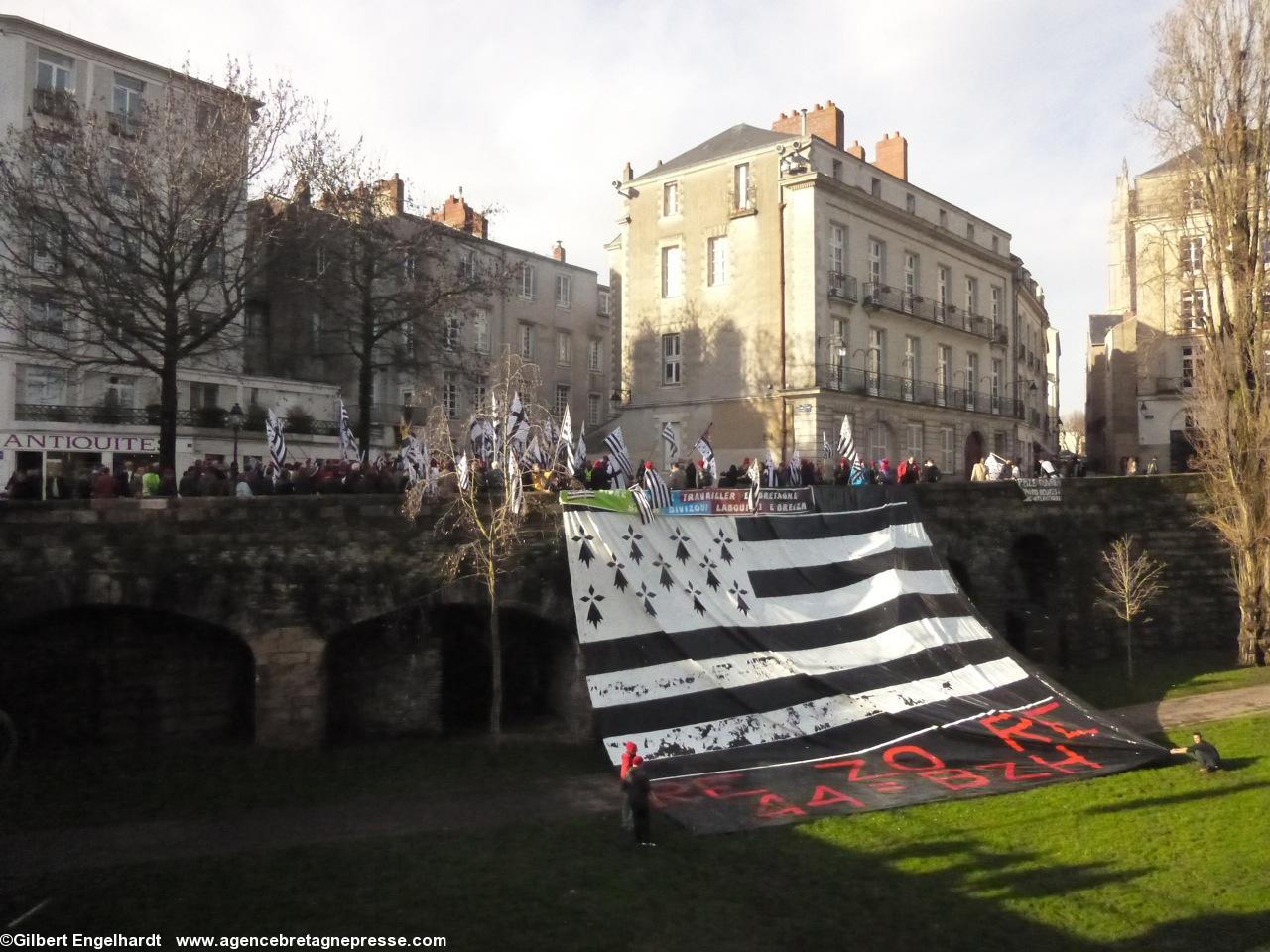 Le <i>gwenn ha du</i> géant bordé à la hâte de la bande <i>Re 'zo re 44=Bzh</i> dont la peinture n'était pas très sèche, a été déployé au-dessus des douves. Le <i>gwenn ha du</i> géant bordé à la hâte de la bande <i>Re 'zo re 44=Bzh</i> dont la peinture n'était pas très sèche, a été déployé au-dessus des douves.