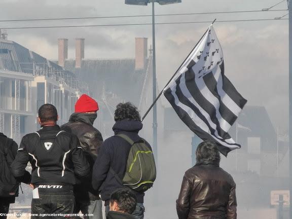 16h53. À proximité de l'Hôtel-Dieu. Au fond le château. Image emblématique de manifestants calmes, juchés sur un point haut, face aux grenades lacrymogènes. Mais des éléments incontrôlés sont hors-champ, en contrebas, en position avancée. A cet endroit, la situation sur le terrain est peu lisible. Et l'attitude des forces de l'ordre est peu intelligible. Manifestation anti-aéroport à Nantes le 22 février 2014. 16h53. À proximité de l'Hôtel-Dieu. Au fond le château. Image emblématique de manifestants calmes, juchés sur un point haut, face aux grenades lacrymogènes. Mais des éléments incontrôlés sont hors-champ, en contrebas, en position avancée. A cet endroit, la situation sur le terrain est peu lisible. Et l'attitude des forces de l'ordre est peu intelligible. Manifestation anti-aéroport à Nantes le 22 février 2014.