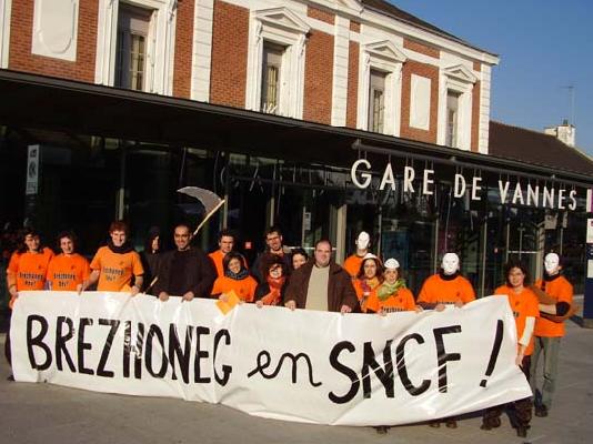 Devant la gare les membres du collectif déploient leur banderole;